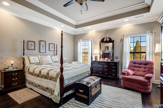 bedroom with ceiling fan, dark hardwood / wood-style flooring, a raised ceiling, and crown molding