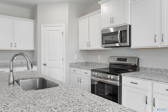 148 Aurora Cir, Fayetteville, TN 37334 - kitchen with stainless steel appliances, a sink, white cabinets, and light stone counters