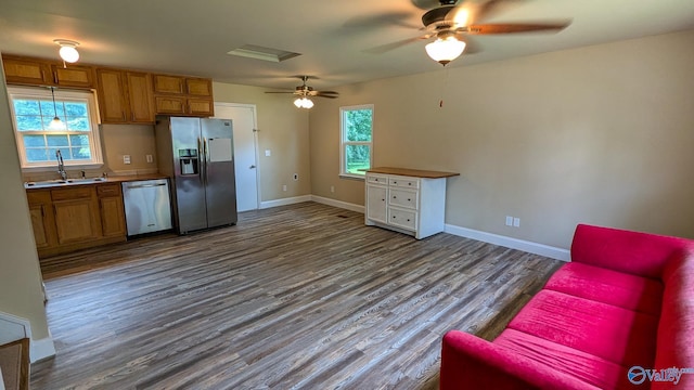 3703 Fox Trail Cir, Huntsville, AL 35810 - kitchen with stainless steel appliances, a sink, brown cabinetry, dark wood-style flooring, and a ceiling fan