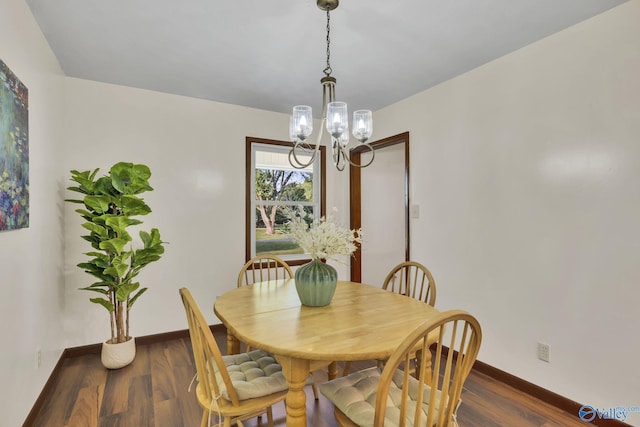 dining room featuring dark hardwood / wood-style flooring and an inviting chandelier