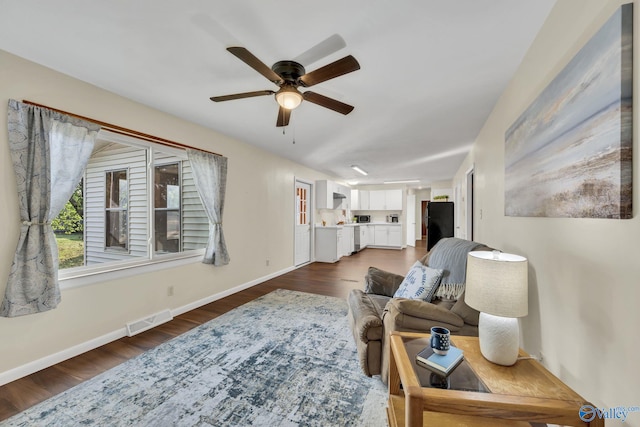 living room with ceiling fan and dark hardwood / wood-style flooring