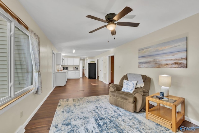 living room with dark hardwood / wood-style flooring and ceiling fan