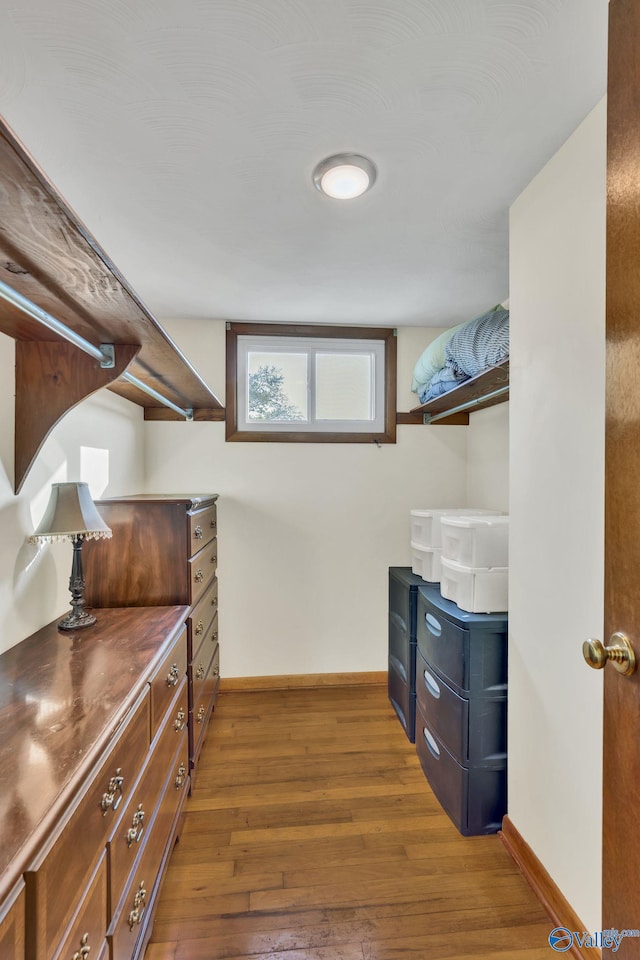 walk in closet with dark wood-type flooring