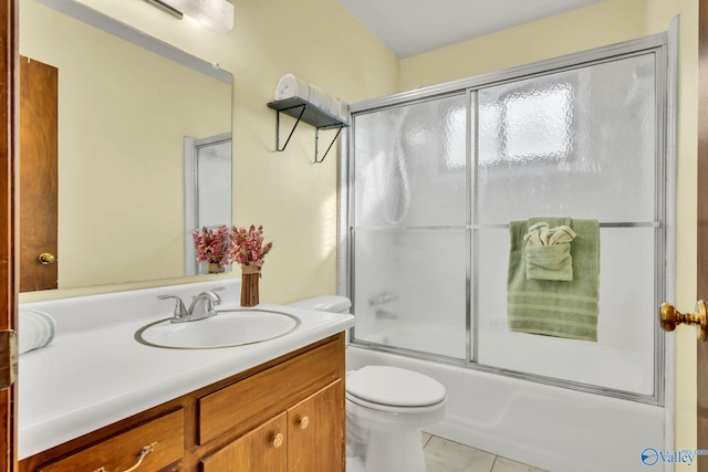 full bathroom with vanity, bath / shower combo with glass door, and toilet