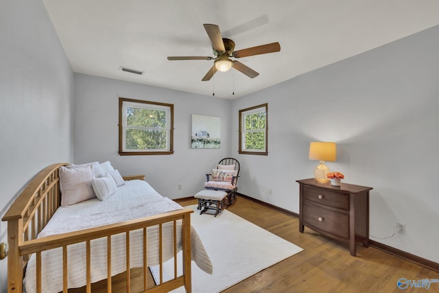 bedroom featuring multiple windows, light wood-type flooring, and ceiling fan