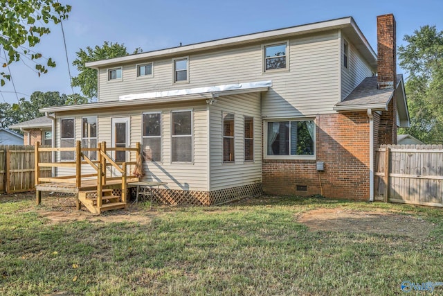 rear view of house featuring a deck and a lawn