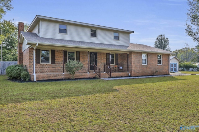 view of front facade featuring a front lawn, covered porch, an outdoor structure, and a garage