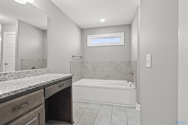 bathroom featuring tile patterned floors, vanity, and a bath