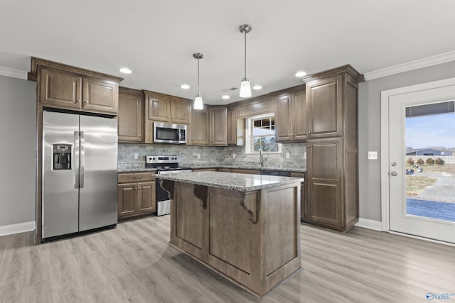 kitchen featuring crown molding, light stone counters, decorative backsplash, appliances with stainless steel finishes, and light wood-style floors