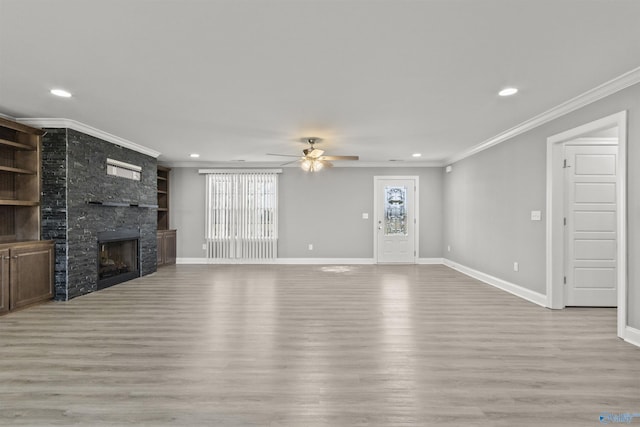 unfurnished living room with light wood-style flooring, a fireplace, baseboards, and ornamental molding