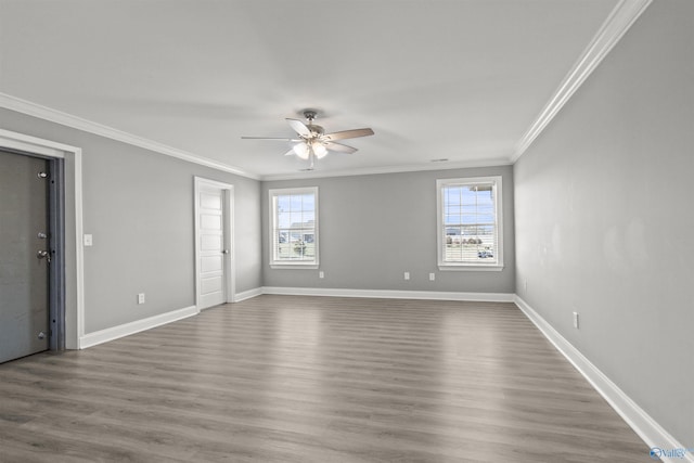 empty room featuring a wealth of natural light, wood finished floors, and ornamental molding