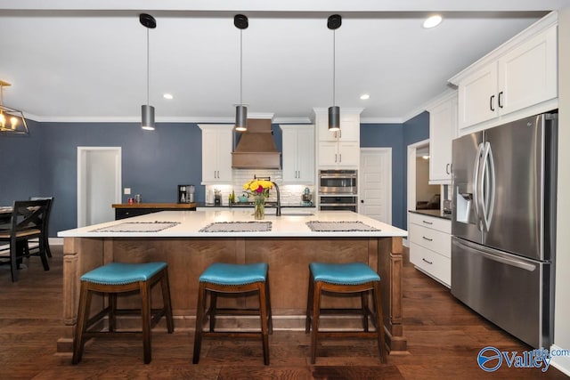7528 Flint Crossing Cir, Owens Cross Roads, AL 35763 - kitchen featuring stainless steel appliances, custom range hood, white cabinetry, decorative backsplash, and crown molding