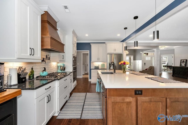 7528 Flint Crossing Cir, Owens Cross Roads, AL 35763 - kitchen featuring custom exhaust hood, appliances with stainless steel finishes, dark wood finished floors, decorative backsplash, and white cabinetry