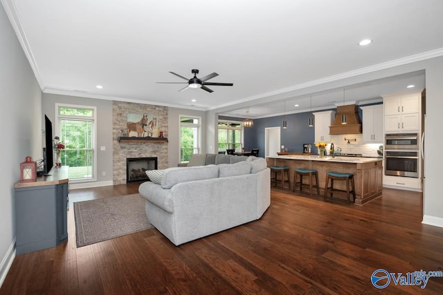 7528 Flint Crossing Cir, Owens Cross Roads, AL 35763 - living room featuring dark wood finished floors, crown molding, a ceiling fan, a fireplace, and recessed lighting