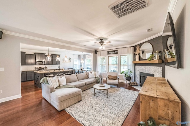 7326 Vidette Ln SE, Owens Cross Roads, AL 35763 - living area featuring dark wood-style flooring, crown molding, a ceiling fan, and a fireplace