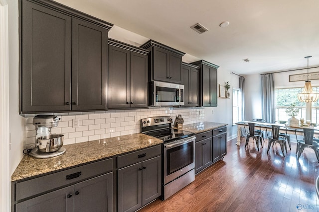 7326 Vidette Ln SE, Owens Cross Roads, AL 35763 - kitchen with appliances with stainless steel finishes, stone counters, decorative backsplash, dark wood-style floors, and a chandelier