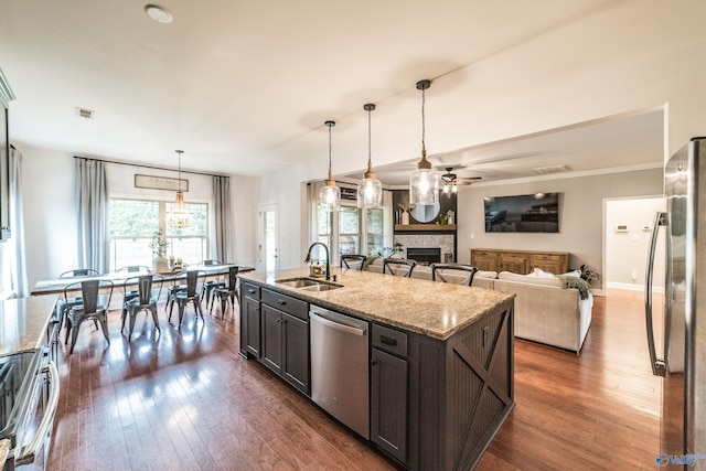 7326 Vidette Ln SE, Owens Cross Roads, AL 35763 - kitchen with appliances with stainless steel finishes, a fireplace, dark wood-style floors, and a ceiling fan