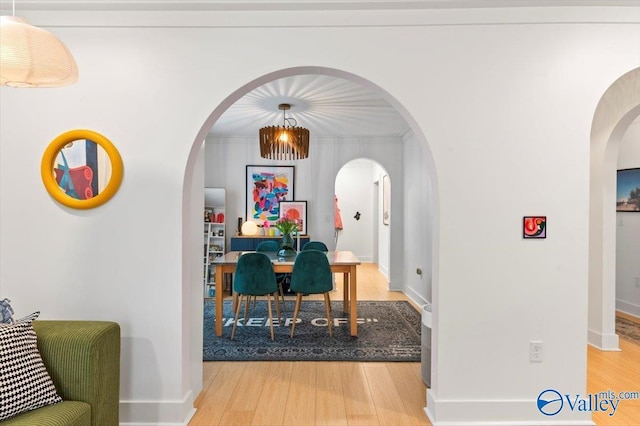 dining area featuring hardwood / wood-style flooring and ornamental molding