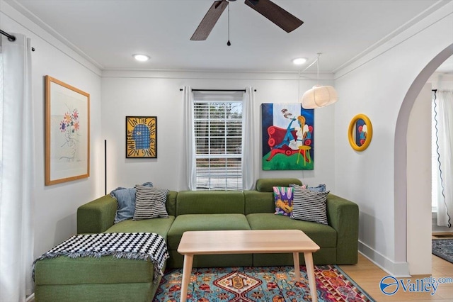 living room featuring light wood-type flooring, ceiling fan, and crown molding