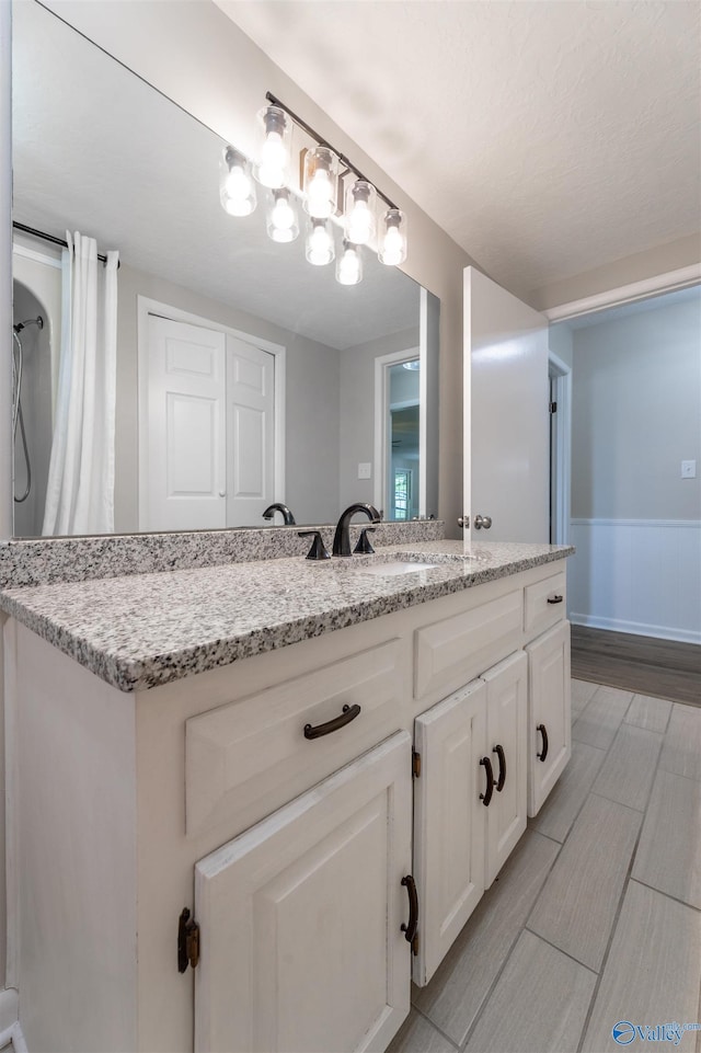 814 E Haven Dr, Glencoe, AL 35905 - bathroom with vanity, wood finished floors, and wainscoting