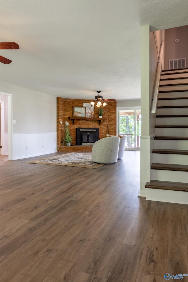 814 E Haven Dr, Glencoe, AL 35905 - living room with ceiling fan, wood finished floors, stairs, a fireplace, and wainscoting