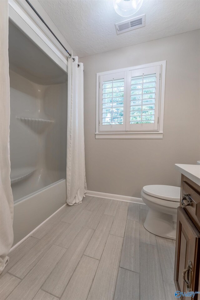 814 E Haven Dr, Glencoe, AL 35905 - full bathroom with vanity, shower / bath combo, a textured ceiling, and wood finished floors