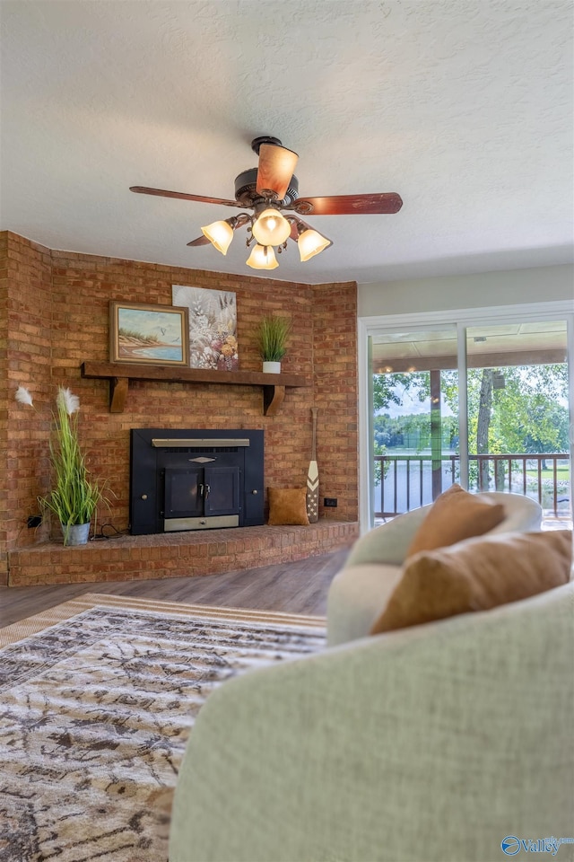 814 E Haven Dr, Glencoe, AL 35905 - living area featuring a fireplace, a ceiling fan, and wood finished floors