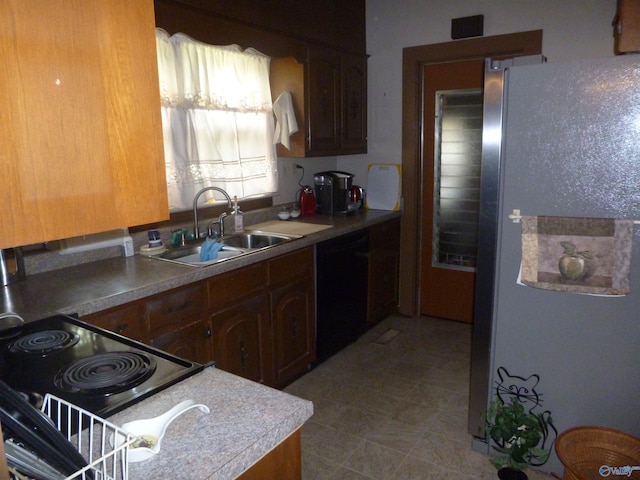kitchen with freestanding refrigerator, a sink, dishwasher, and light countertops