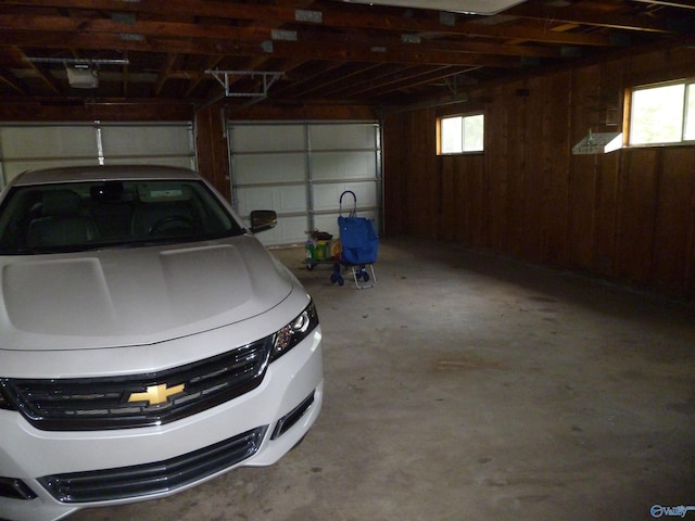 garage with wooden walls and a garage door opener