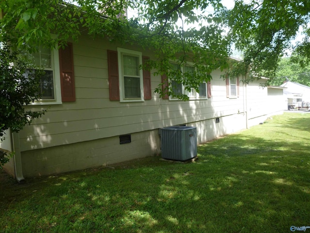 view of side of property featuring a lawn, crawl space, and cooling unit