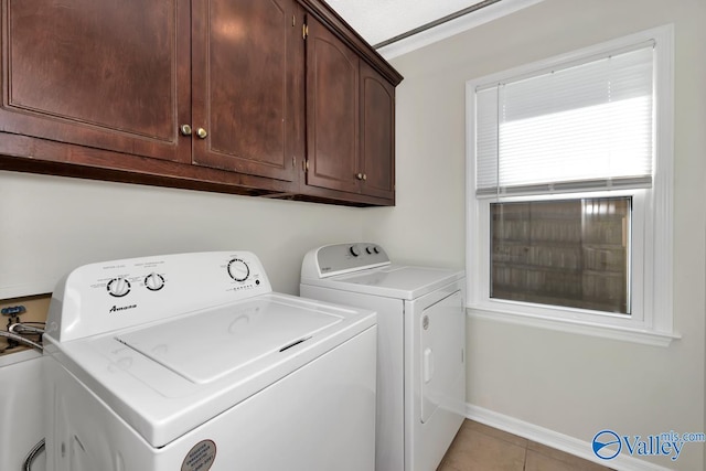 clothes washing area featuring independent washer and dryer, cabinets, and light tile patterned flooring