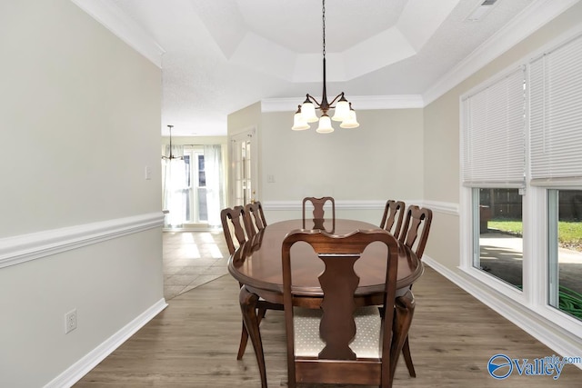 dining space with a chandelier, dark wood-type flooring, a healthy amount of sunlight, and ornamental molding