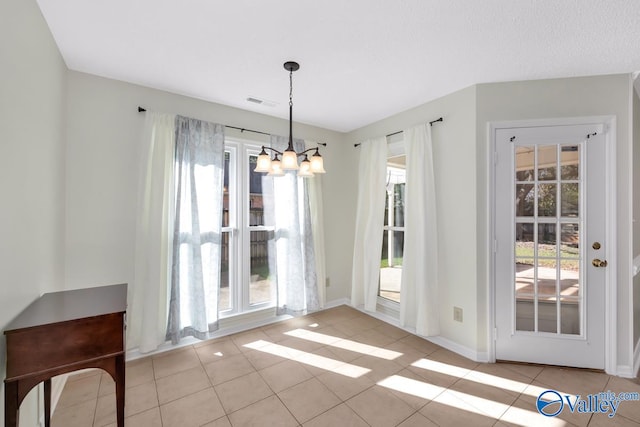 doorway to outside with light tile patterned floors and a notable chandelier