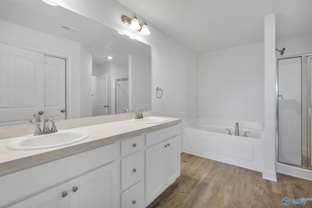 2452 Belltown Dr, Huntsville, AL 35803 - bathroom with a shower stall, wood finished floors, double vanity, and a bath