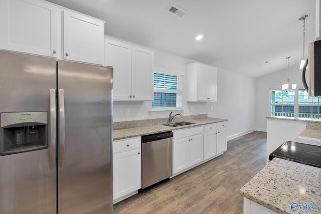 2452 Belltown Dr, Huntsville, AL 35803 - kitchen featuring appliances with stainless steel finishes, a sink, light wood-type flooring, white cabinetry, and light stone counters