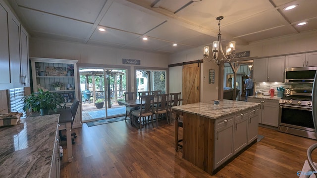 kitchen featuring gray cabinets, appliances with stainless steel finishes, coffered ceiling, dark hardwood / wood-style floors, and a kitchen island