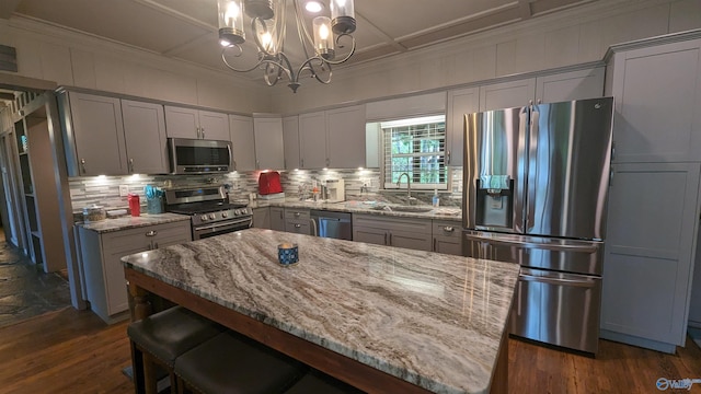 kitchen featuring sink, light stone countertops, backsplash, stainless steel appliances, and dark hardwood / wood-style flooring