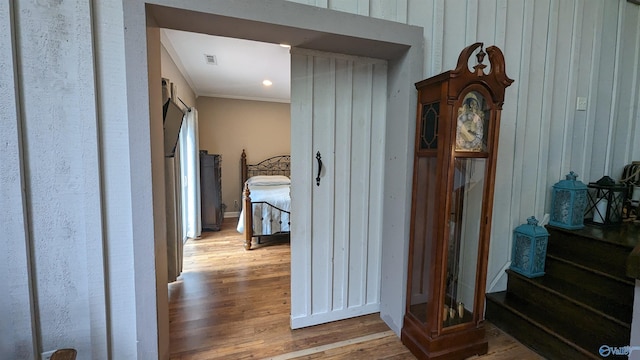 corridor featuring wood walls, visible vents, and wood finished floors