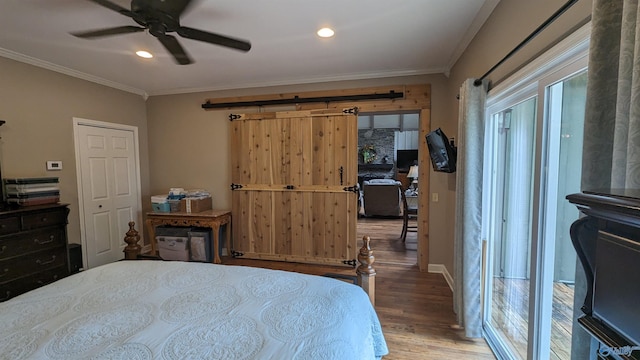 bedroom with ceiling fan, wood-type flooring, ornamental molding, and a closet