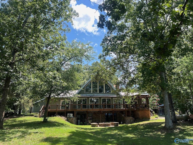 back of property with stairs, a deck, and a yard