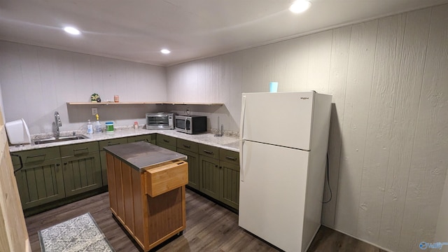 kitchen featuring sink, wood walls, dark hardwood / wood-style floors, and white refrigerator