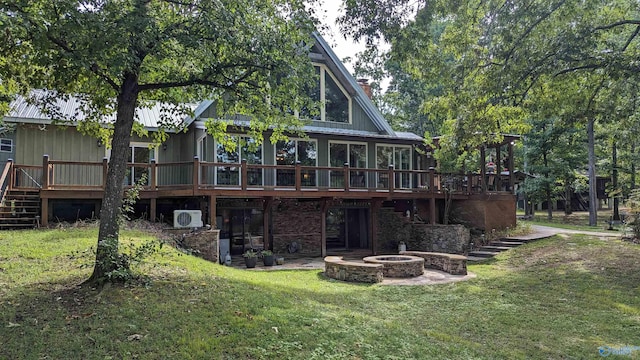 rear view of house with a fire pit, a chimney, stairway, a yard, and a wooden deck