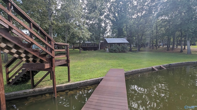 view of dock with a lawn and stairway