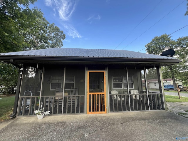 view of front of home featuring metal roof and a porch