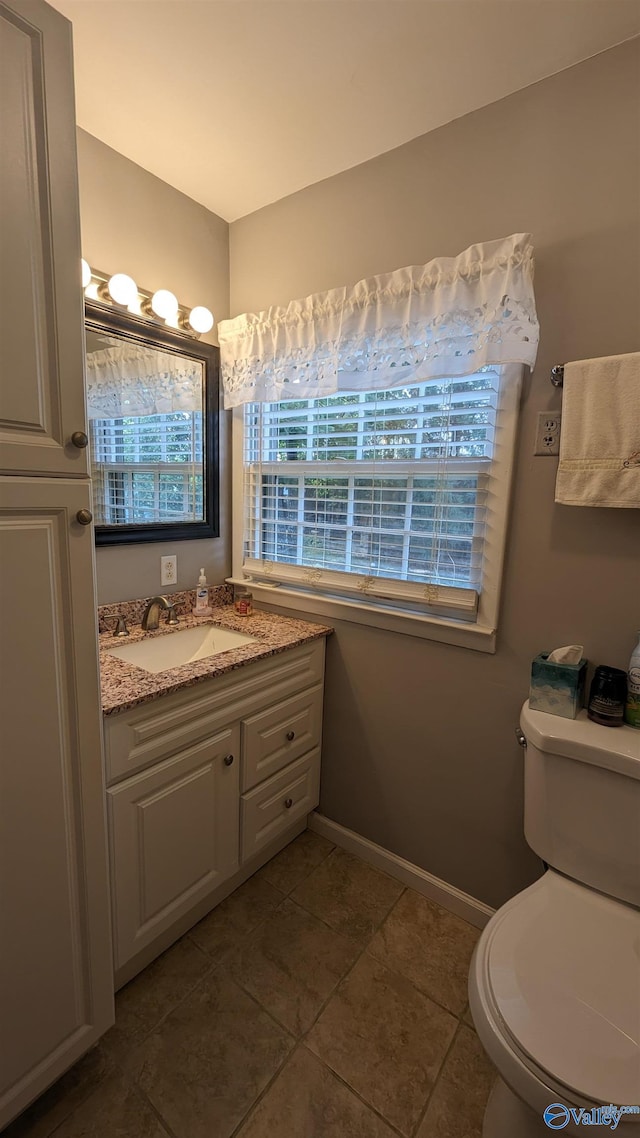 bathroom featuring toilet, vanity, and tile patterned flooring