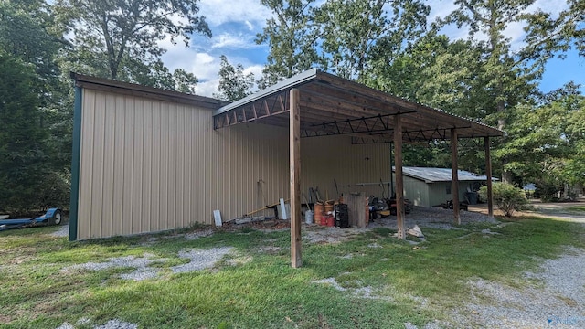 exterior space with a carport, an outbuilding, driveway, and a lawn