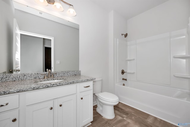 full bathroom featuring washtub / shower combination, vanity, and toilet