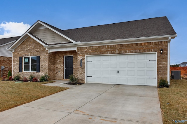 view of front of property with a garage, cooling unit, and a front lawn