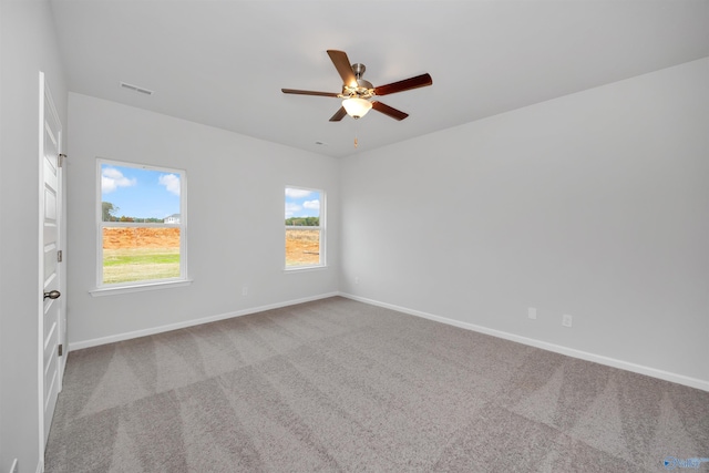 carpeted spare room featuring ceiling fan