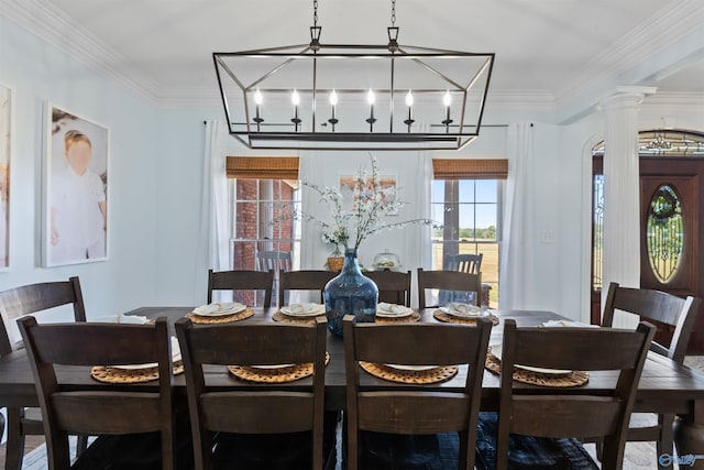 dining room featuring decorative columns, ornamental molding, and an inviting chandelier